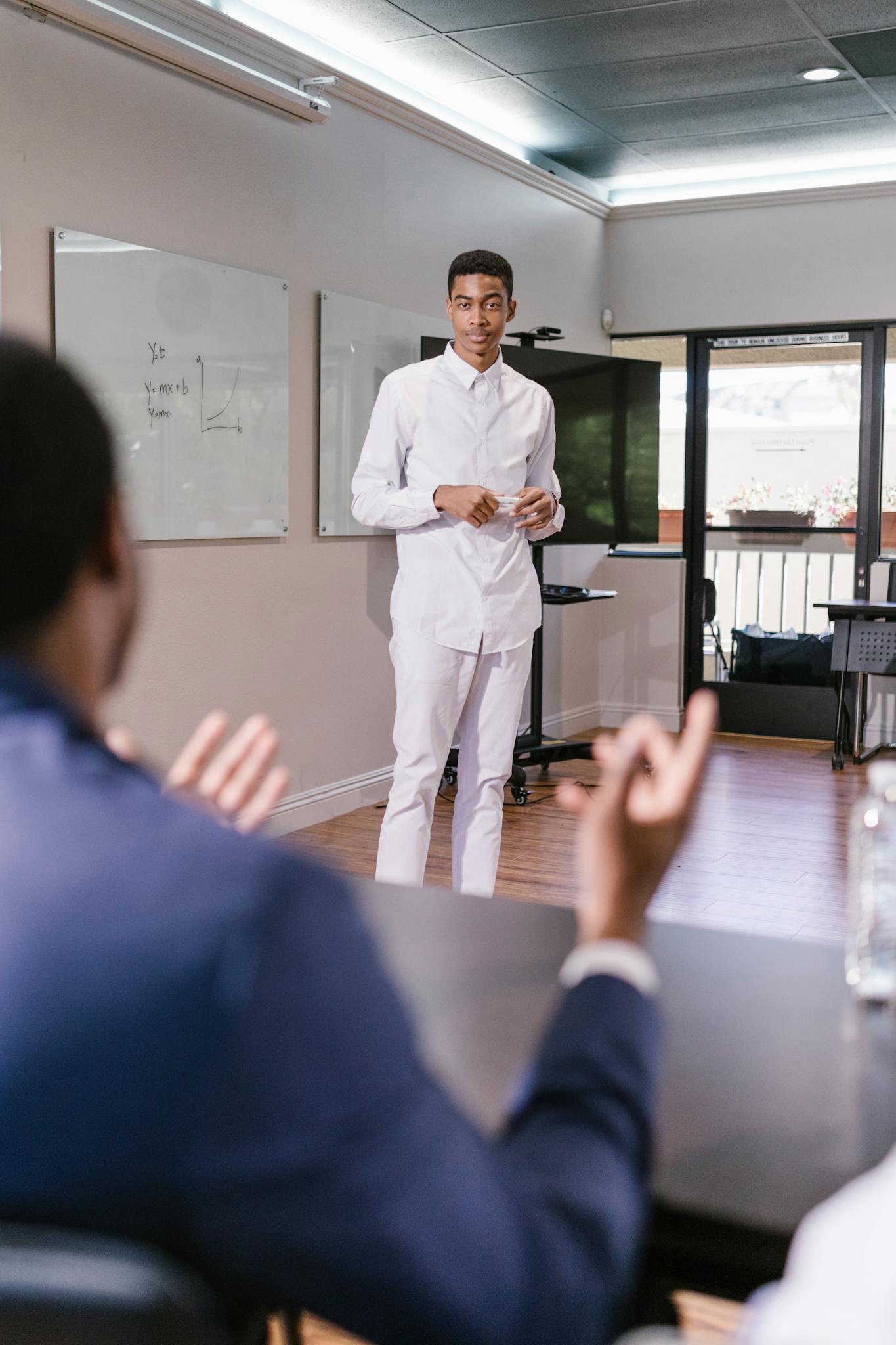 Young professional presenting in a modern office. Group engaged in a discussion.