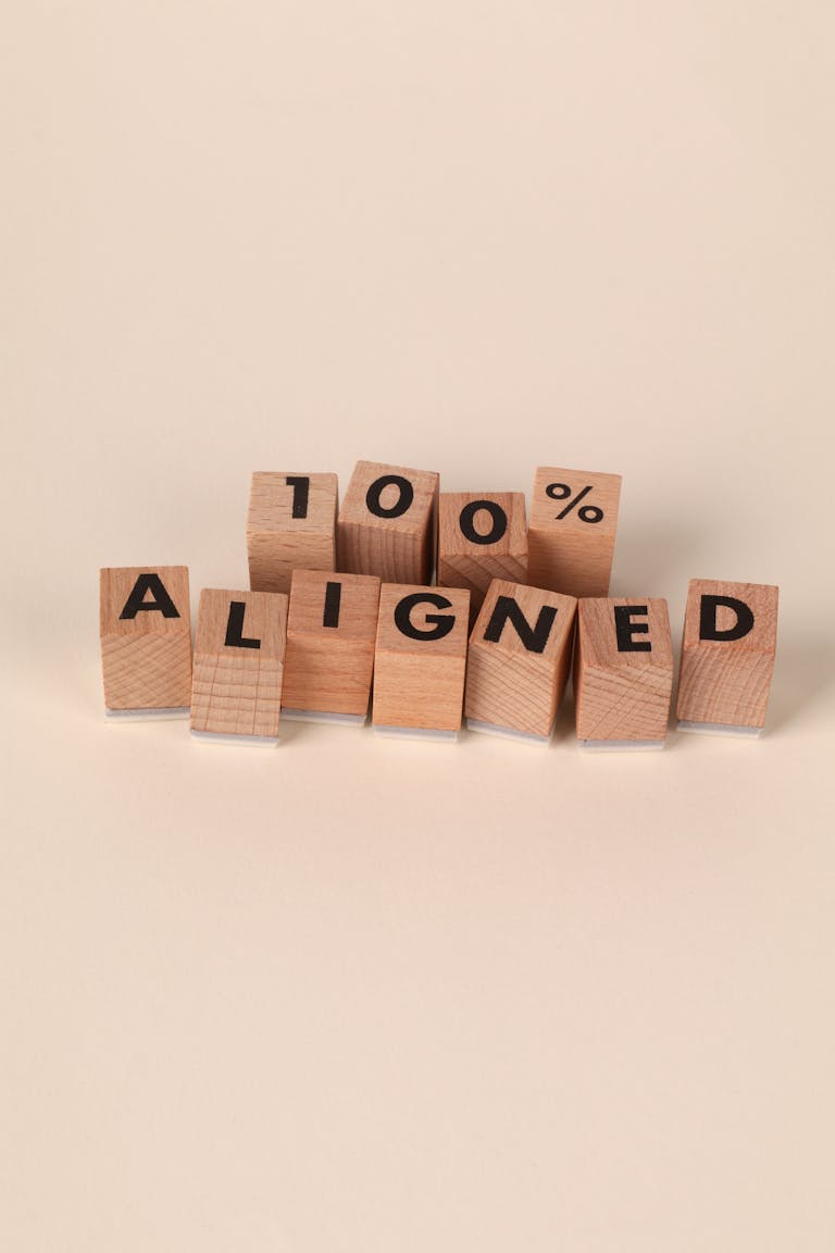 Wooden blocks arranged to spell '100% Aligned,' symbolizing precision and alignment.